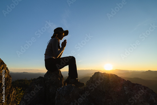 Silhouette of The girl prayed in the mountains to think of a loving God, we praise God.