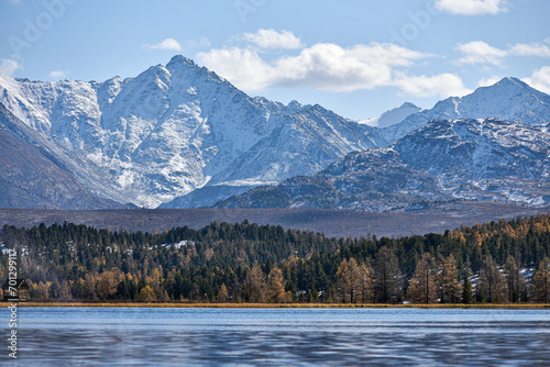 Mountain landscape. Mountain lake in autumn against the backdrop of snowy peaks.