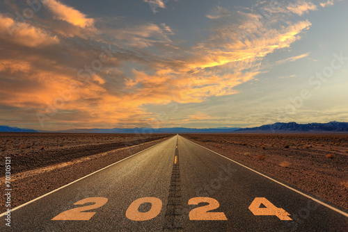 2024 written on asphalt road at sunset