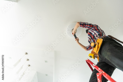 electrician installing led light bulbs in ceiling lamp photo