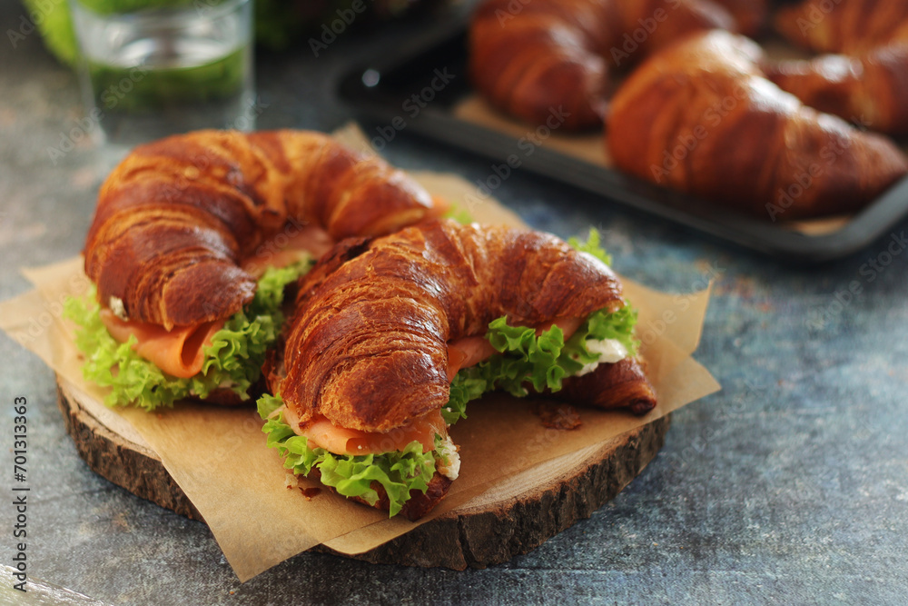 Freshly baked croissants with salmon and salad on the table Freshly baked croissants with salmon and salad on the table