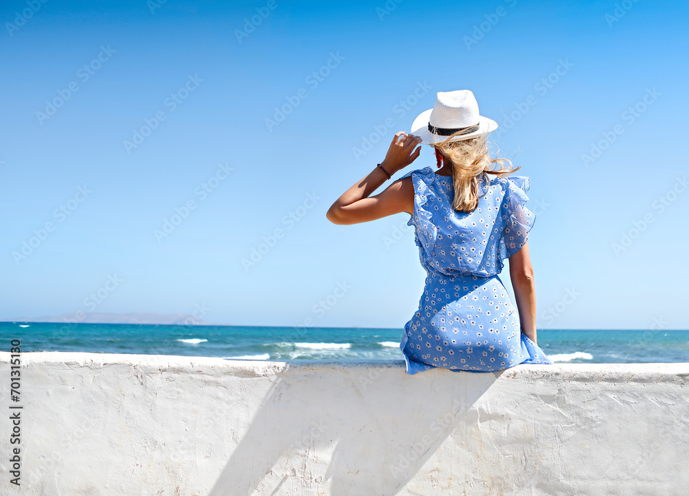 Young woman in summer dress with straw hat