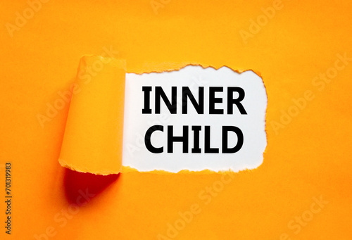 Inner child symbol. Concept words Inner child on beautiful white paper. Beautiful orange table orange background. Psychological, motivational inner child concept. Copy space.
