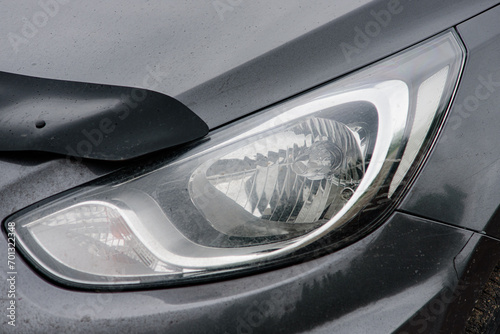 Halogen headlight on a gray car. Close-up.