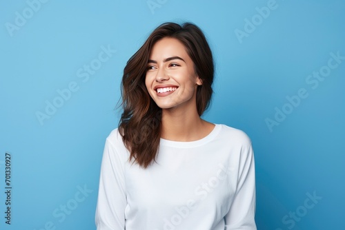Photo of attractive brunette young woman wearing casual clothes standing isolated over blue background photo