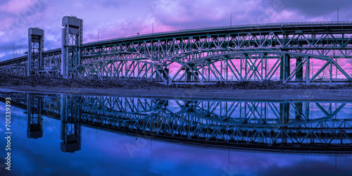 Gold Star Memorial Bridge in New London, Connecticut, the arching landmark suspending bridge over the Thames River, reflected symmetrical shapes over the water at twilight photo