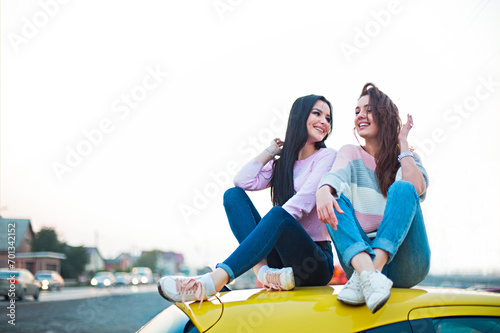 Best female friends cheering by car road trip at sunset. Happy people outdoor on vacation tour © Dasha Petrenko