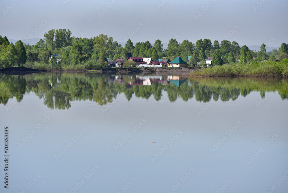 Fototapeta premium Village on the shore of a reservoir in summer.