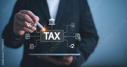 Businessman use tablet  to complete Individual income tax return form online for tax payment. Financial research,government taxes and calculation tax return concept. Tax and Vat concept. photo
