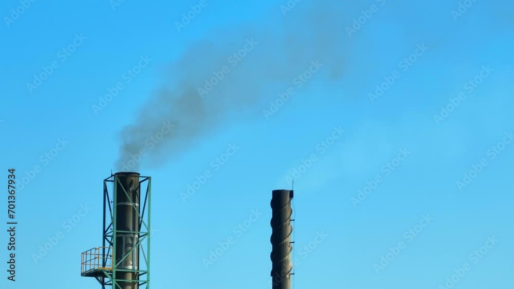 Environmental Crisis: An industrial plant billows thick black smoke, a stark contrast against the once pristine blue sky, symbolizing the urgent need to address air pollution. Aerial view drone. Environmental Crisis: An industrial plant billows thick black smoke, a stark contrast against the once pristine blue sky, symbolizing the urgent need to address air pollution. Aerial view drone.
