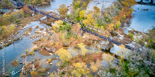Train bridge in autumn over a river surrounded by colorful trees