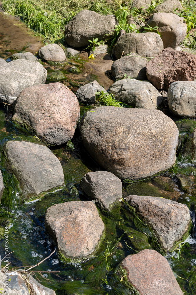 water flowing in a small narrow stream in summer water flowing in a small narrow stream in summer