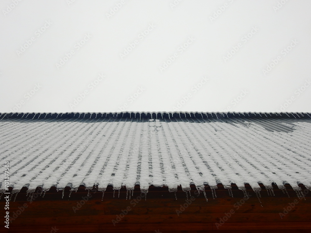 Obraz premium Frosted country house roof with icicles abstract