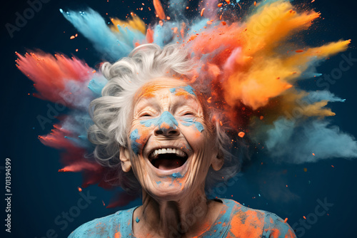 Portrait of an elderly woman in the midst of a color powder explosion