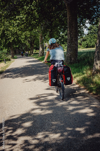 M  dchen auf Radreise f  hrt eine Allee entlang