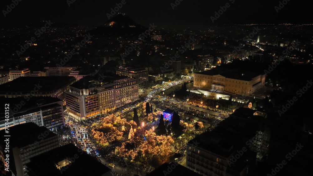 Aerial drone night shot of illuminated iconic Syntagma square at new year's eve celebration with fireworks welcoming 2024, Athens, Attica, Greece