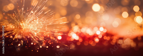 Gold and dark red background with firework Sparkler. © Michal
