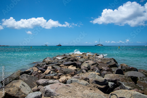 A groyne of rocks reaches out into the Caribbean sea from Frigate bay