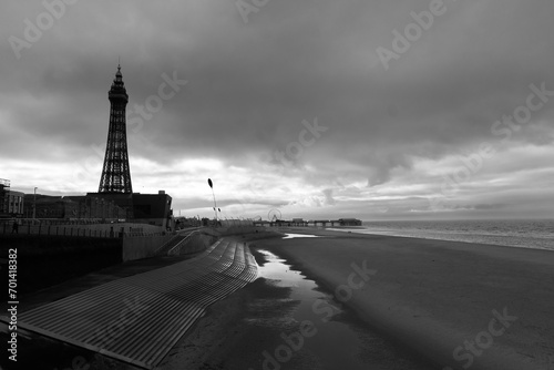 A moody Black and white photo along Blackpool beach with the pier and tower in silhouette