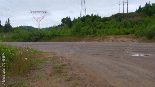 Various power lines and towers in forest, tilt up.