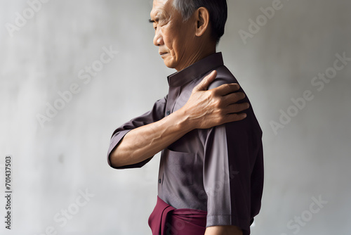 Stiffness in shoulder joint of Asian man. Frozen shoulder or arm muscle power problem.