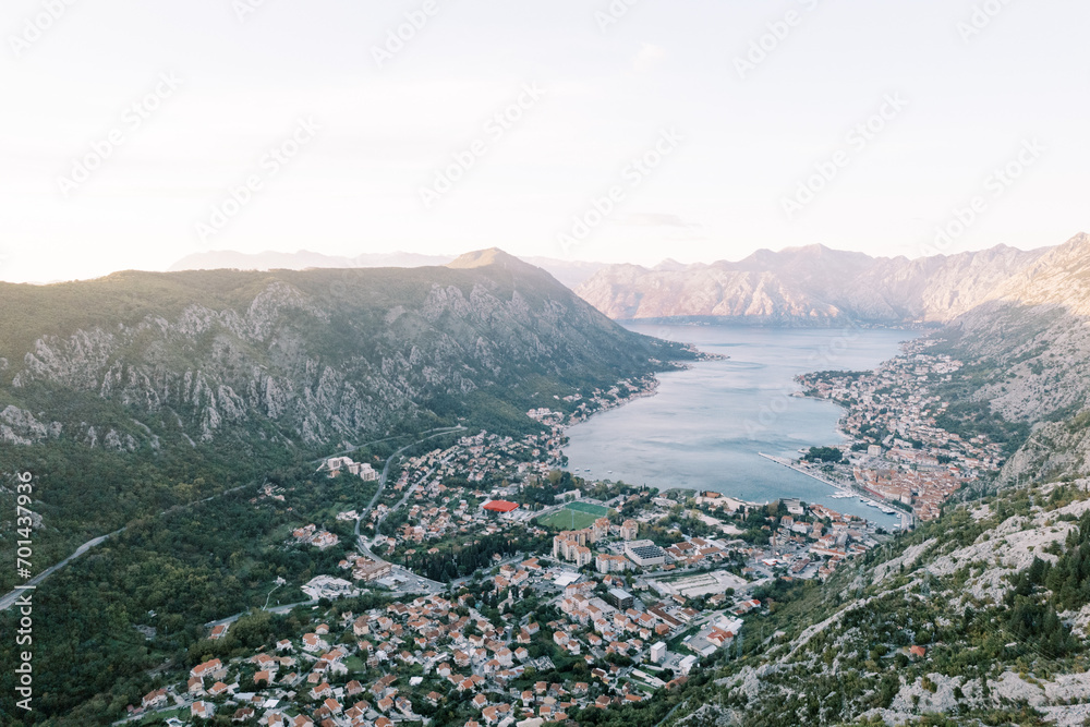 View from the mountain of an ancient town with red roofs in the Bay of Kotor, surrounded by mountains. Montenegro