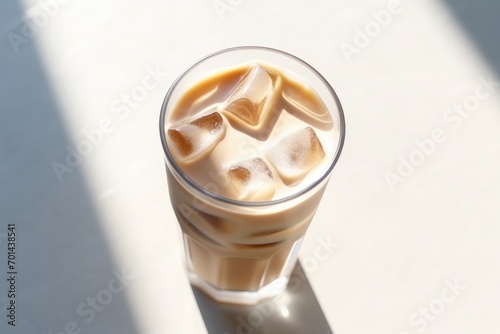 Iced coffee in a tall glass with sunlight casting shadows