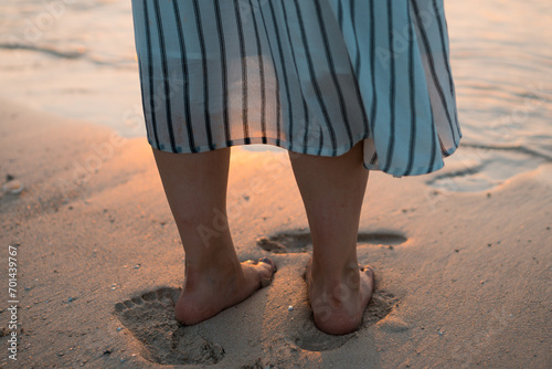砂浜を歩く女性の足元 © tibagorou