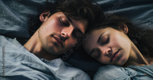 A young and beautiful couple lies relaxed on the bed in the morning light, sharing intimate moments of love and happiness. The concept reflects the warmth and closeness of youthful affection.