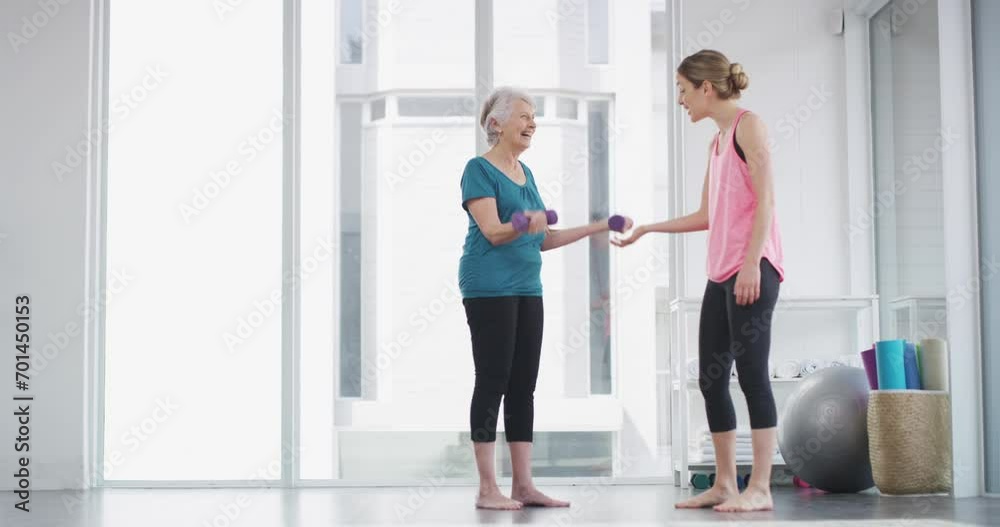Elderly, woman and coach with dumbbell for workout, exercise or fitness with communication and instructions. Senior, person and personal trainer with weight lifting, training and conversation at gym Elderly, woman and coach with dumbbell for workout, exercise or fitness with communication and instructions. Senior, person and personal trainer with weight lifting, training and conversation at gym