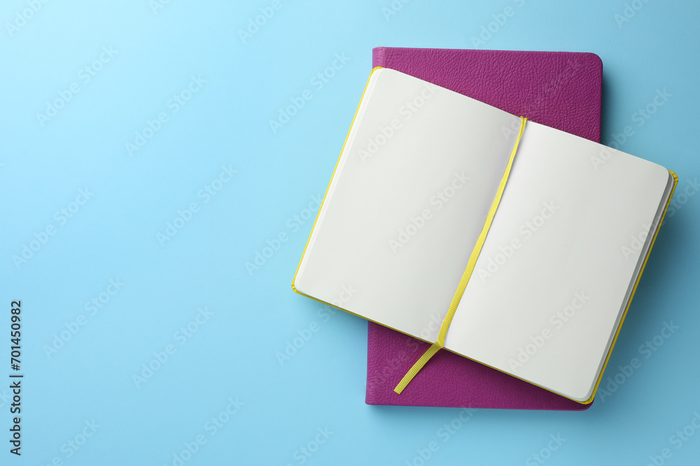 Different notebooks on light blue background, top view. Space for text Different notebooks on light blue background, top view. Space for text