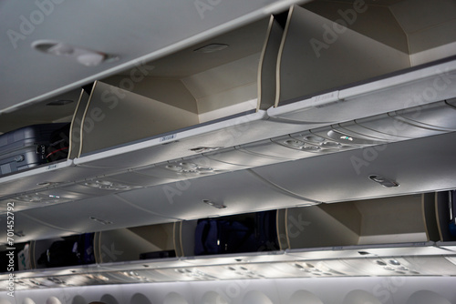 Fotografia Open overhead luggage compartment in an airplane during boarding