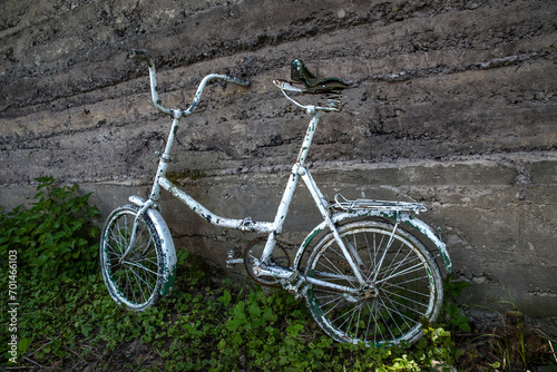 Old bicycle near the concrete wall.