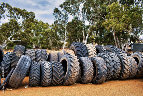 Rows of used truck- and tractor tires in an Australian junkyard, eucalyptus trees in the background, Wongan Hills, Western Australia photo