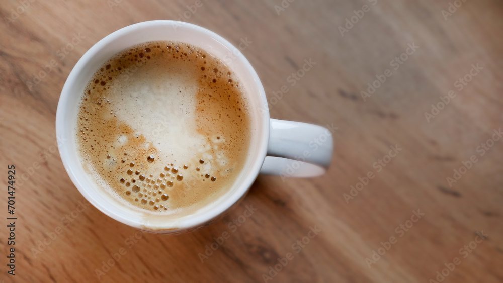 Cup of coffee on a wooden table. View from above Cup of coffee on a wooden table. View from above