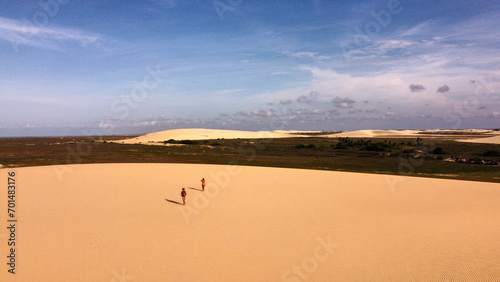 The sand dunes with its shades of colors in Jeriocoacoara in Brazil, the beach, the long rocky coast and the trees palm