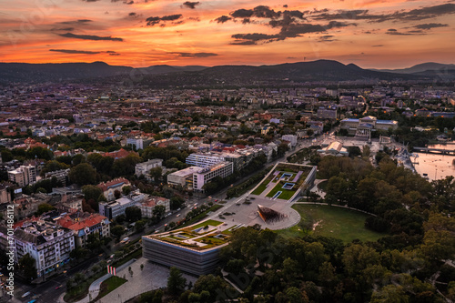 Budapest, Hungary - Aerial view of the Museum of Ethnography at City Park with Heroes' Square and skyline of Budapest at background with dramatic colorful sunset over the capital of Hungary