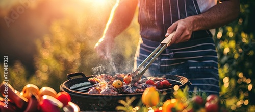 Man cooking tasty food on barbecue grill outdoors closeup. Creative Banner. Copyspace image photo