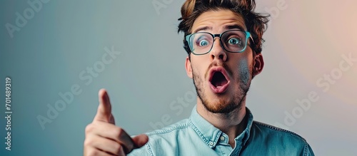 Middle age latin man wearing casual clothes and glasses pointing with finger surprised ahead open mouth amazed expression something on the front. Creative Banner. Copyspace image