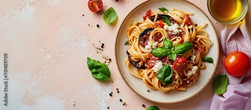 Pasta with eggplant tomato sauce basil served with grated ricotta salata cheese Pasta alla Norma pasta salad Pink and beige table surface Directly above vertical image. Creative Banner