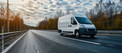 White delivery van on the highway White modern delivery small shipment cargo courier van moving fast on motorway road to city urban suburb The world s best transport of goods. Creative Banner photo