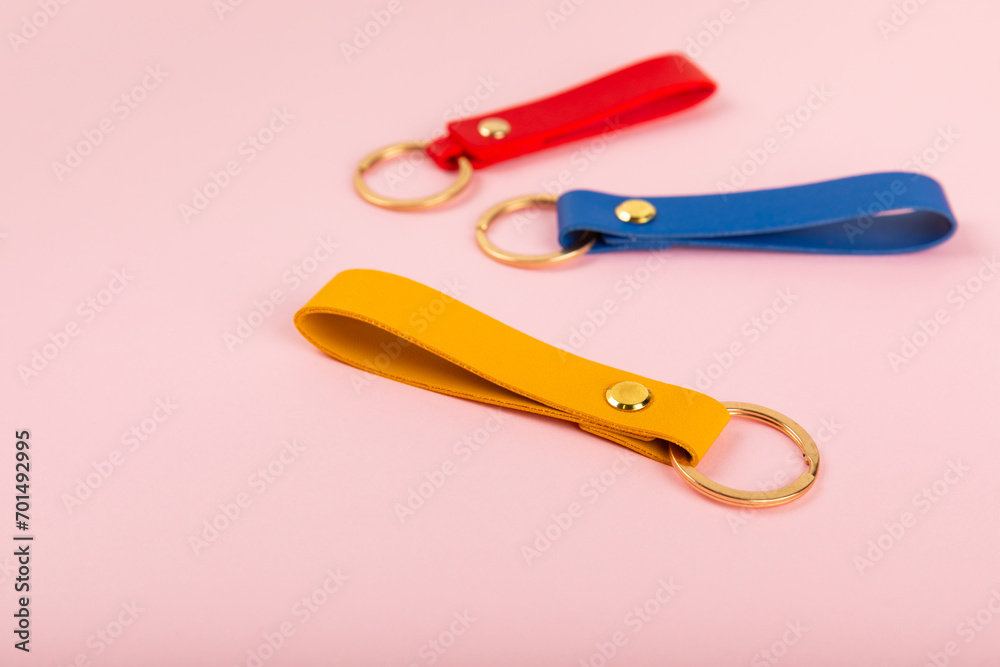 Leather keychain with a key ring on a pink background. Concepts for real estate and moving home or renting property. Buying a property. Mock-up keychain.Copy space. Leather keychain with a key ring on a pink background. Concepts for real estate and moving home or renting property. Buying a property. Mock-up keychain.Copy space.