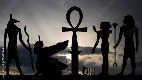 Hieroglyphic with Key of Life, Time Lapse at Sunrise with Fast Clouds and Dark Silhouette of Egyptian Simbols photo