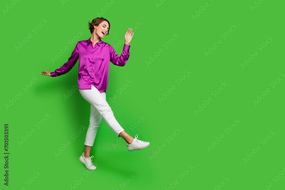 Full length photo of optimistic adorable lady dressed stylish outfit seasonal sale shopping empty space isolated on green color background Full length photo of optimistic adorable lady dressed stylish outfit seasonal sale shopping empty space isolated on green color background