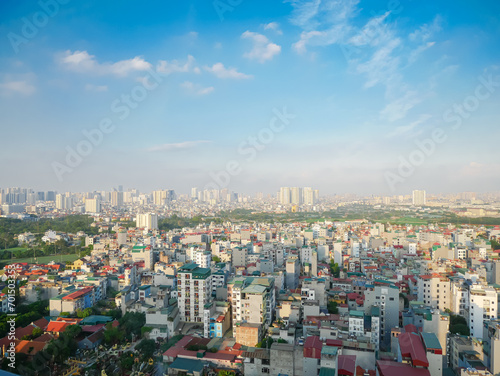 Dense of multistory residential houses with caged balcony and row of high-rise apartment tower complex in background at Van Quan, Ha Dong District, Southwest of Hanoi, Vietnam