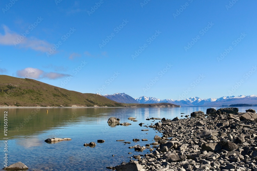 New Zealand lake with rocks and mirror lake with mountains 