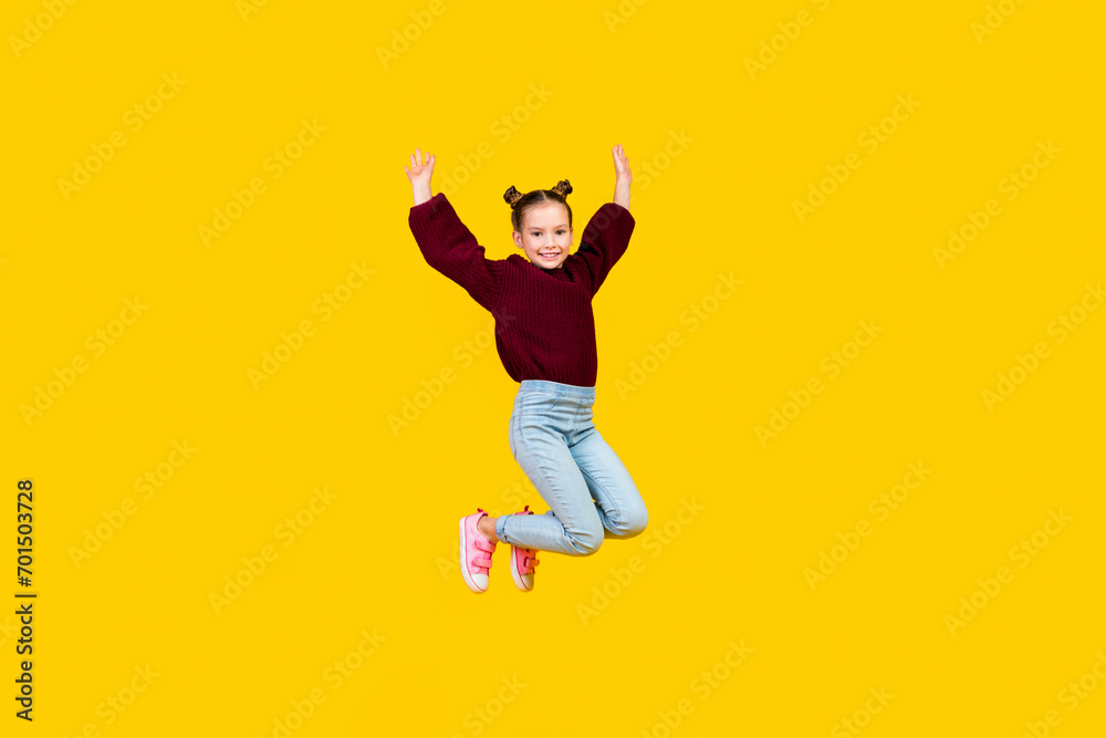Full size portrait of cheerful carefree girl jumping flying raise hands isolated on yellow color background