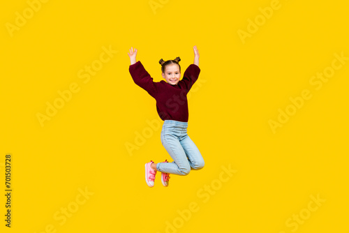 Full size portrait of cheerful carefree girl jumping flying raise hands isolated on yellow color background © deagreez