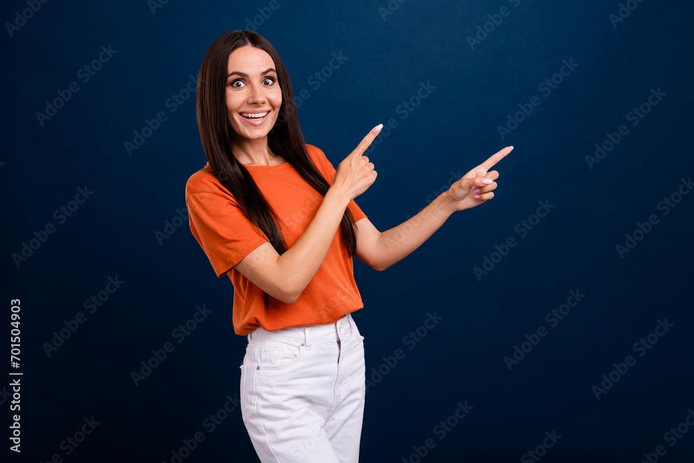 Portrait of ecstatic person with long hair wear stylish clothes directing at impressive offer empty space isolated on dark blue background Portrait of ecstatic person with long hair wear stylish clothes directing at impressive offer empty space isolated on dark blue background