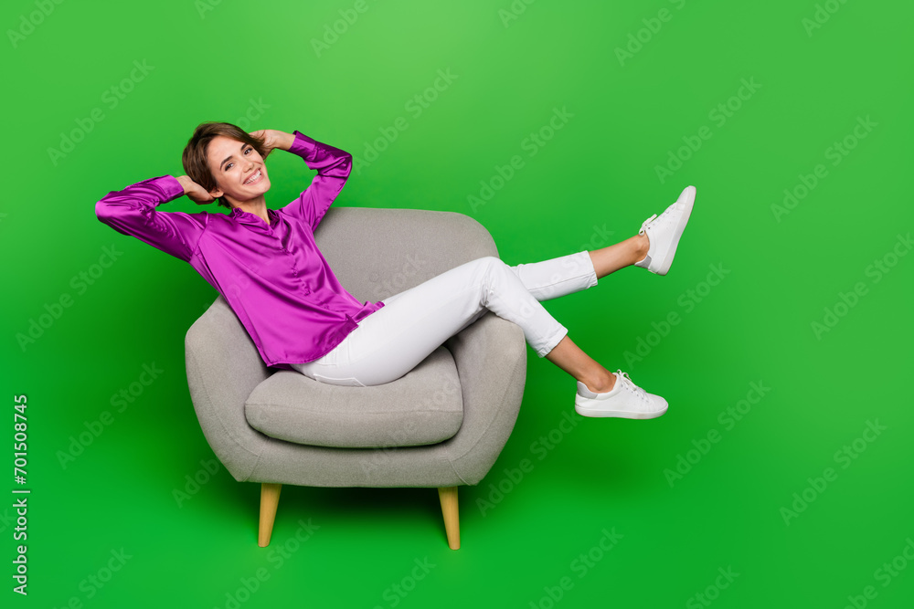 Full body photo of young cheerful lady take nap laying comfortable gray armchair in office and have fun isolated on green color background Full body photo of young cheerful lady take nap laying comfortable gray armchair in office and have fun isolated on green color background